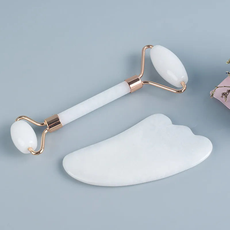 White jade double-headed facial roller and gua sha scraping tool set with a wooden storage board.