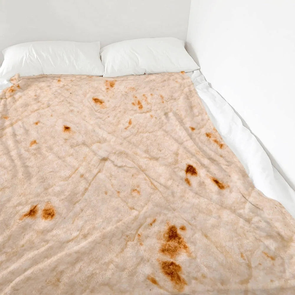 Round coral fleece flannel blanket rolled in a burrito style, showing soft texture and printed design.