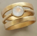 Gold-plated titanium steel ring with a white chalcedony stone in a geometric, micro-inlaid setting.