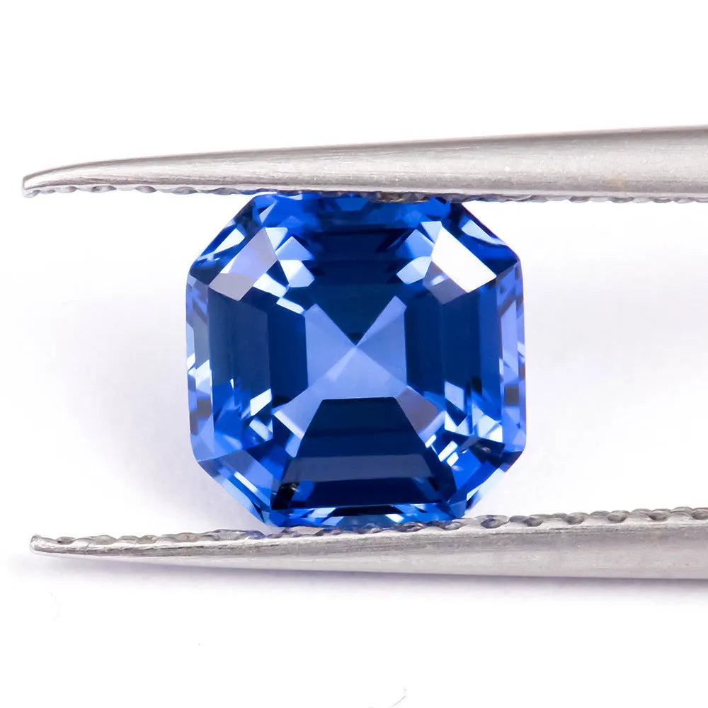 Royal blue loose gemstone in heart, round, and pear shapes on a white background.