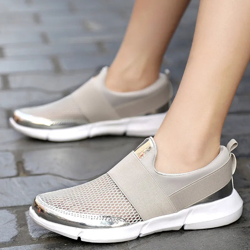 Low-cut blue women's casual sneakers with mesh upper on a hard floor surface.