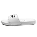 Men's black and white open-toe slippers with a textured rubber sole on a plain background
