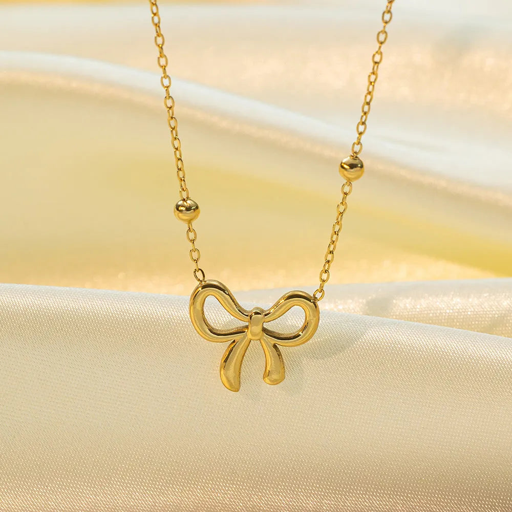 Gold electroplated bow necklace with cross chain design on adjustable 41-50cm chain