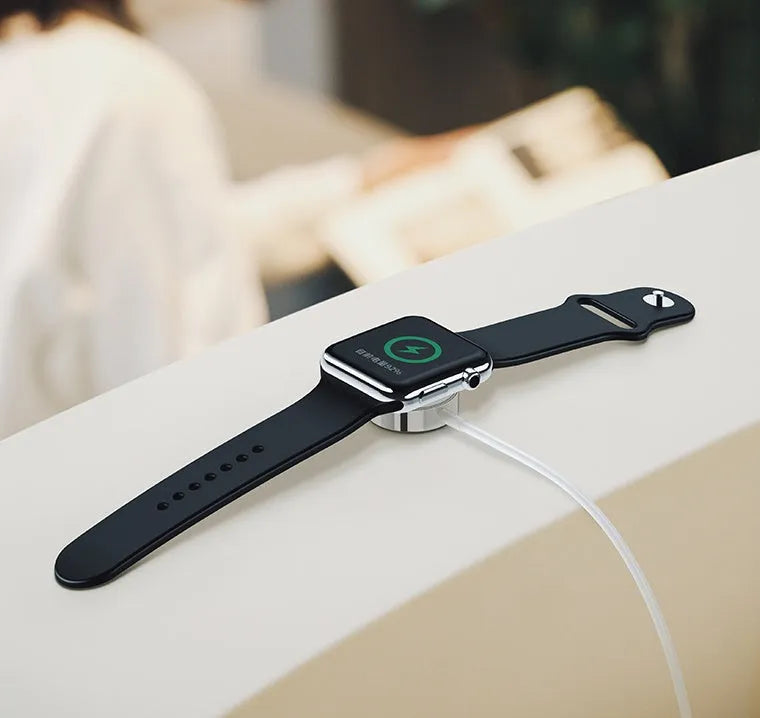 White metal Apple Watch wireless charger with 1m USB cable on a table