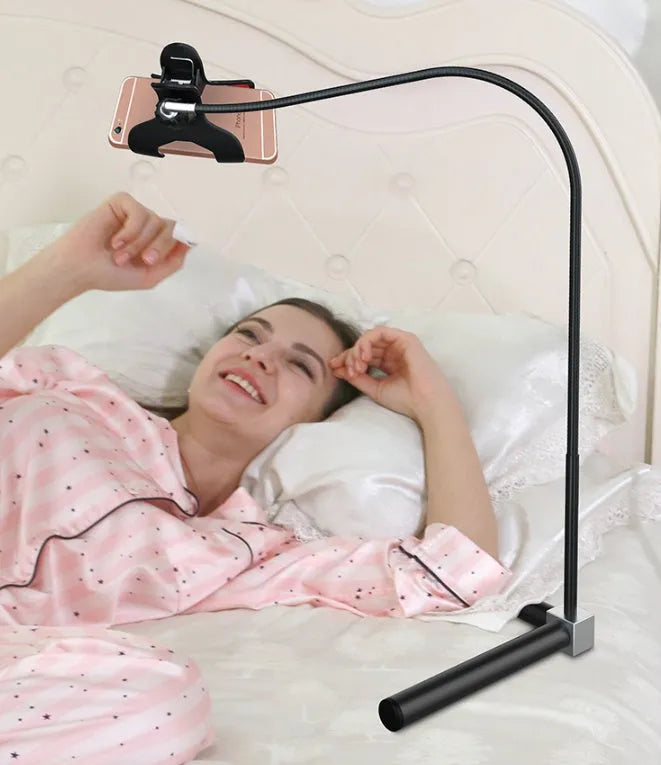 Black bedside mobile phone bracket with universal holder attached to bed frame for hands-free viewing