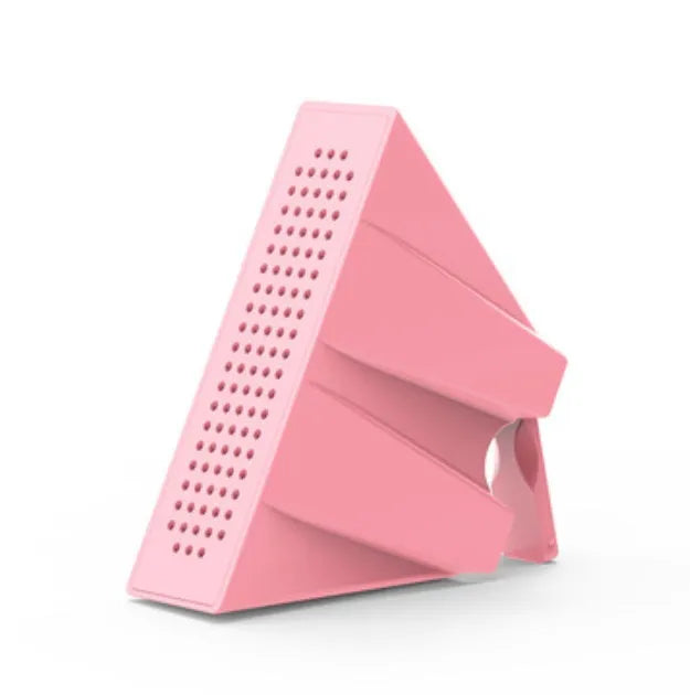 A small, coloured plastic phone amplifier holder holding a mobile phone on a desk.