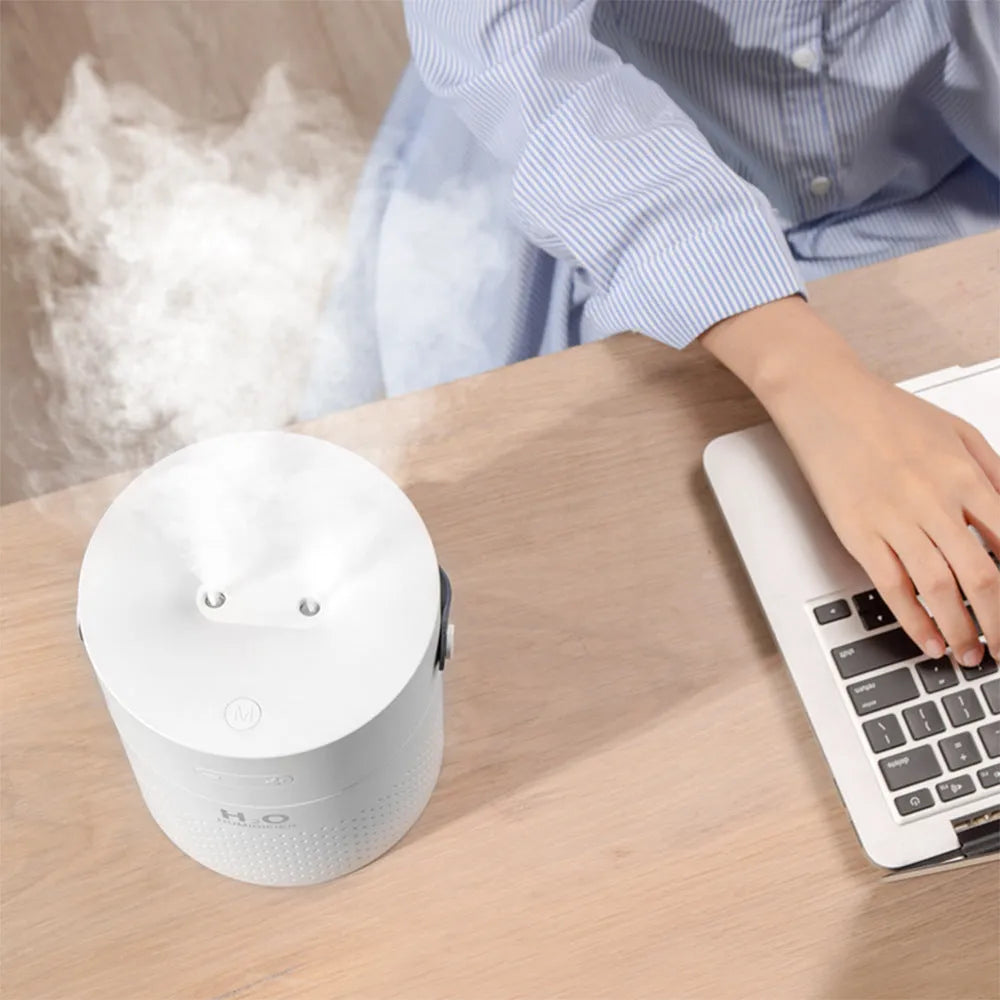 Slim USB rechargeable humidifier with water tank and colour options on a bedside table.