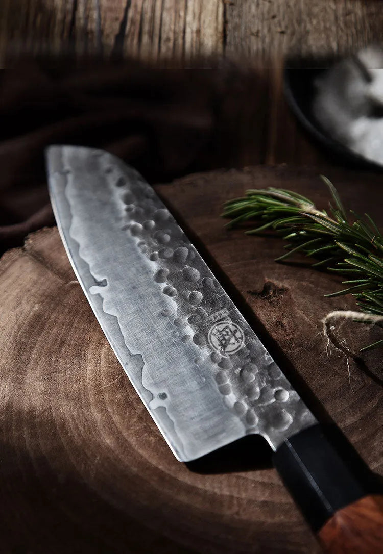 Hand forged Santoku chef knife with 149 cm silver blade on cutting board