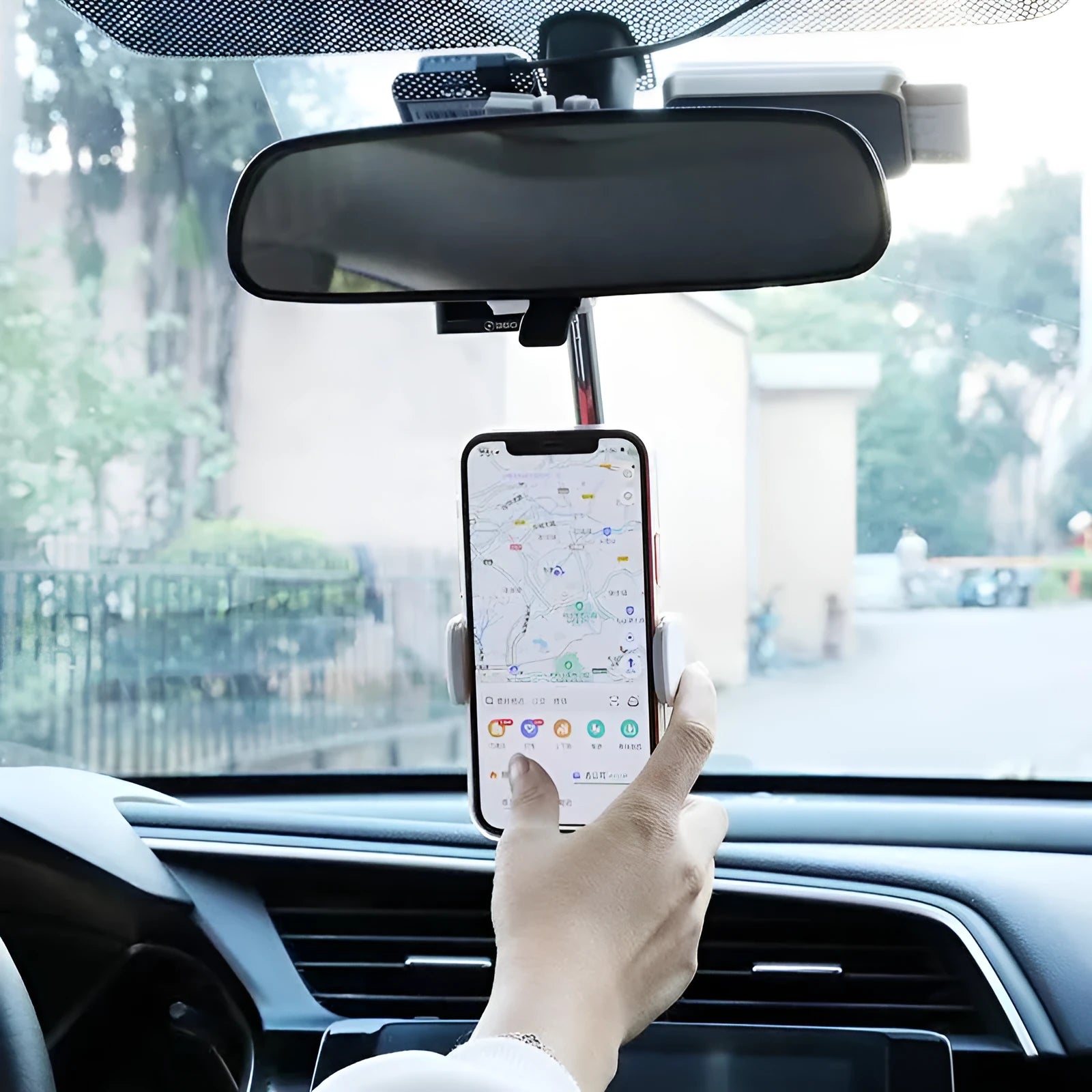 Black ABS plastic mobile phone bracket mounted on car rearview mirror holding smartphone