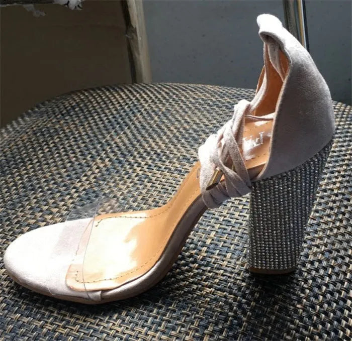Women's black and gold plastic high heel sandals with a pointed toe design.
