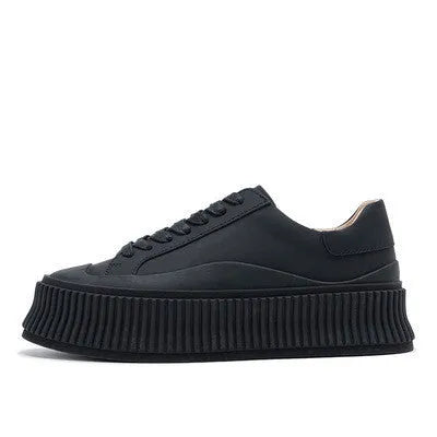Women's black thick sole platform sneakers with back lacing system and suede leather construction