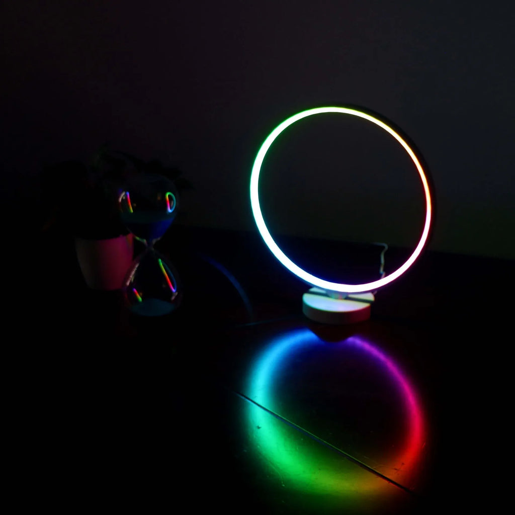White Full Moon table lamp with remote control on a wooden surface.