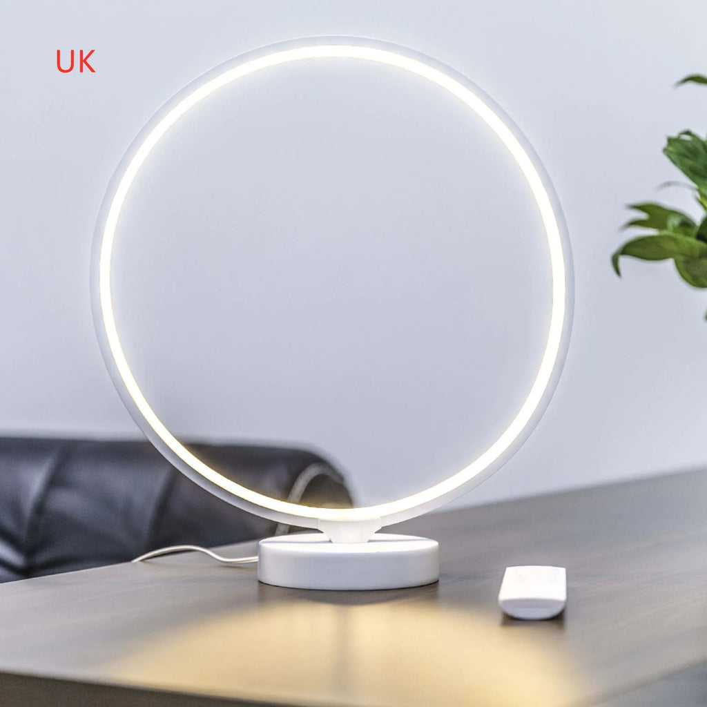White Full Moon table lamp with remote control on a wooden surface.