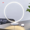 White Full Moon table lamp with remote control on a wooden surface.