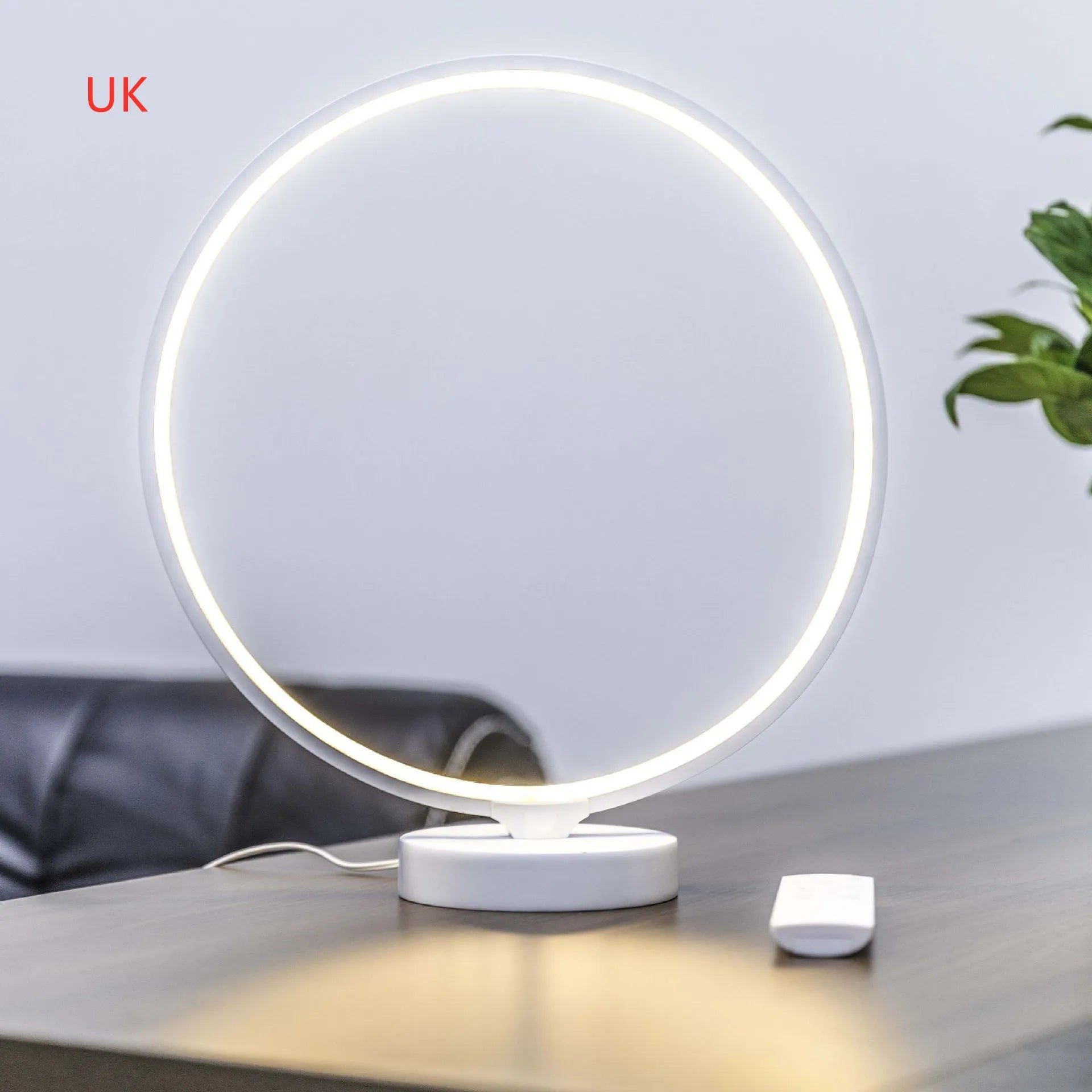 White Full Moon table lamp with remote control on a wooden surface.
