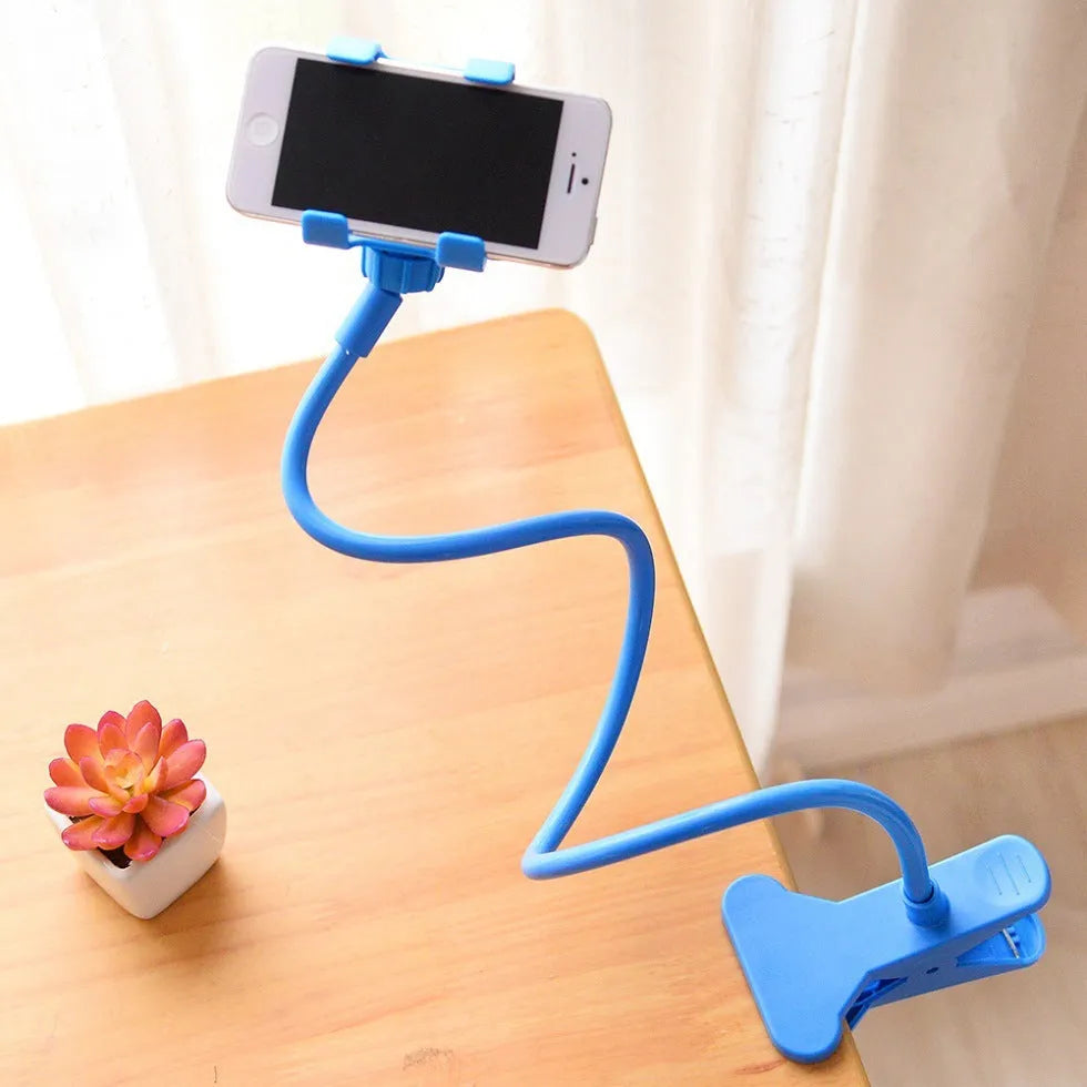 Black portable phone holder with a long flexible arm and a V-shaped clip, extended on a bedside table.