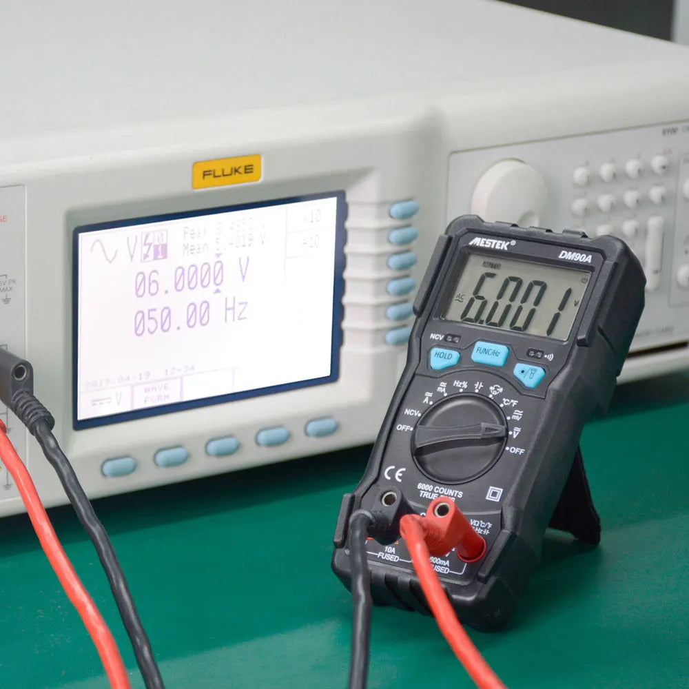 DM90A digital multimeter with display showing reading, test leads, and thermocouple probe on a workbench.