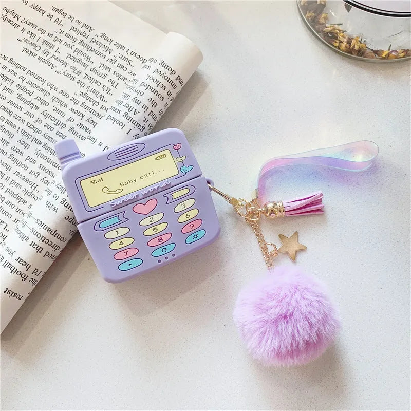 Purple silicone clamshell case for AirPods Pro or AirPods 1 and 2 with a matching fur ball pendant attached.
