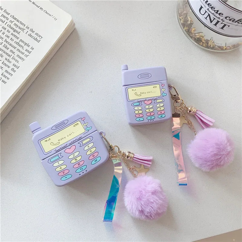 Purple silicone clamshell case for AirPods Pro or AirPods 1 and 2 with a matching fur ball pendant attached.
