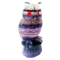 Hand-carved purple fluorite owl ornament on a neutral background, showing natural stone colour and texture.