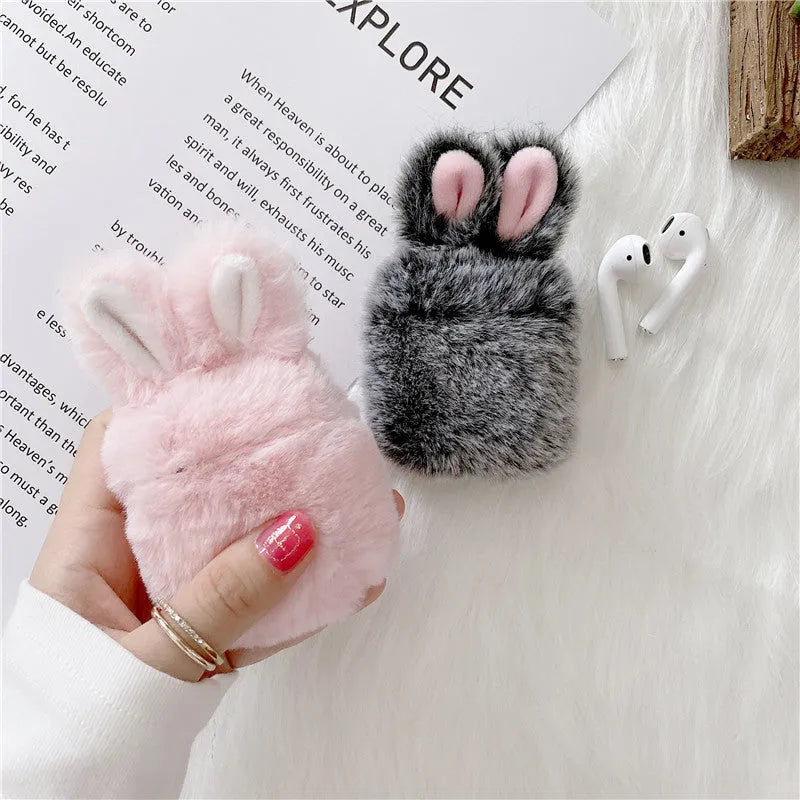 Pink soft silicone AirPods Pro cover with grey plush rabbit ears attached on a white background.