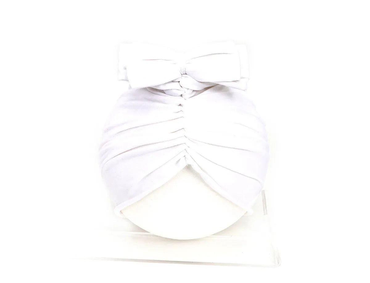 Soft acrylic knitted baby hat in a solid colour, shown on a mannequin as a turban-style cap for infants 0-28 months.
