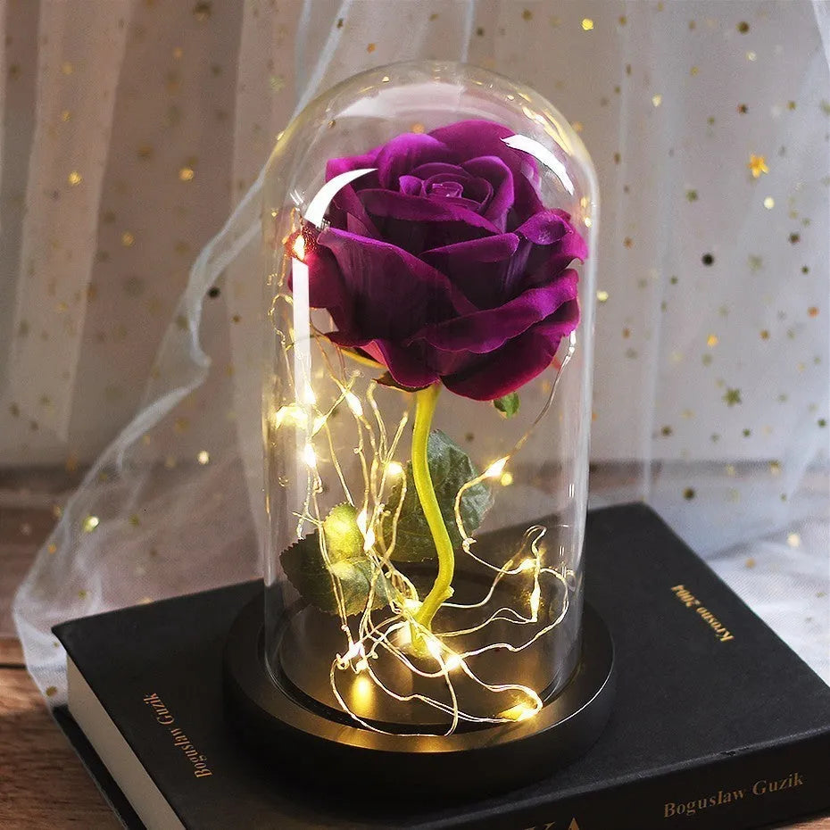 Simulated pink silk rose inside a glass dome with glowing LED fairy lights