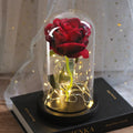 Simulated pink silk rose inside a glass dome with glowing LED fairy lights
