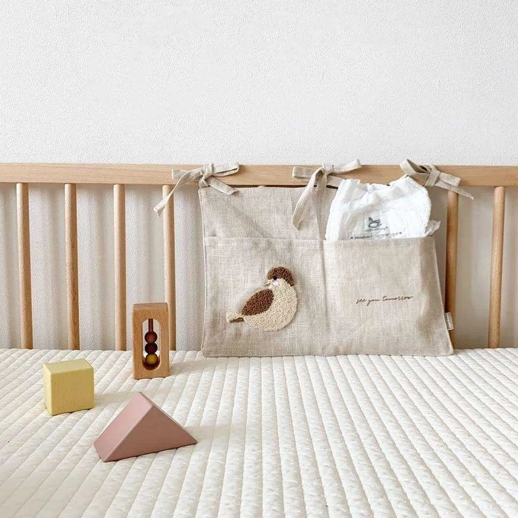 Khaki cotton and linen multi-purpose storage bag hanging beside the bed with single pocket