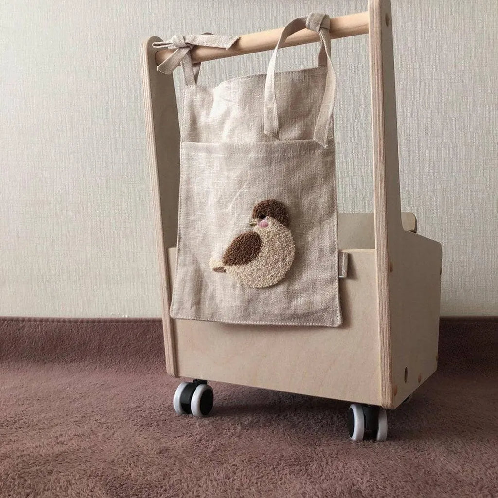 Khaki cotton and linen multi-purpose storage bag hanging beside the bed with single pocket