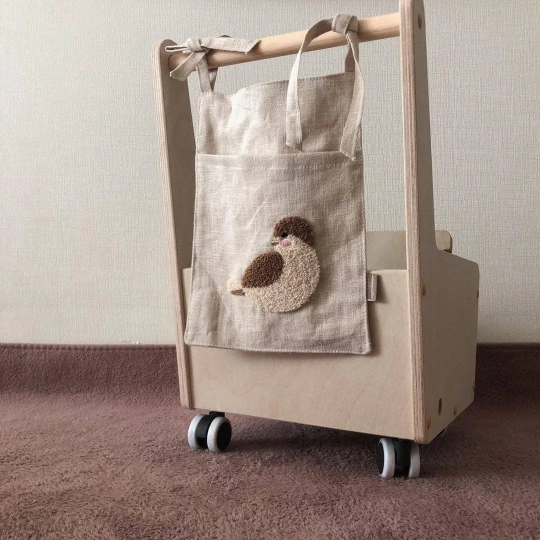 Khaki cotton and linen multi-purpose storage bag hanging beside the bed with single pocket