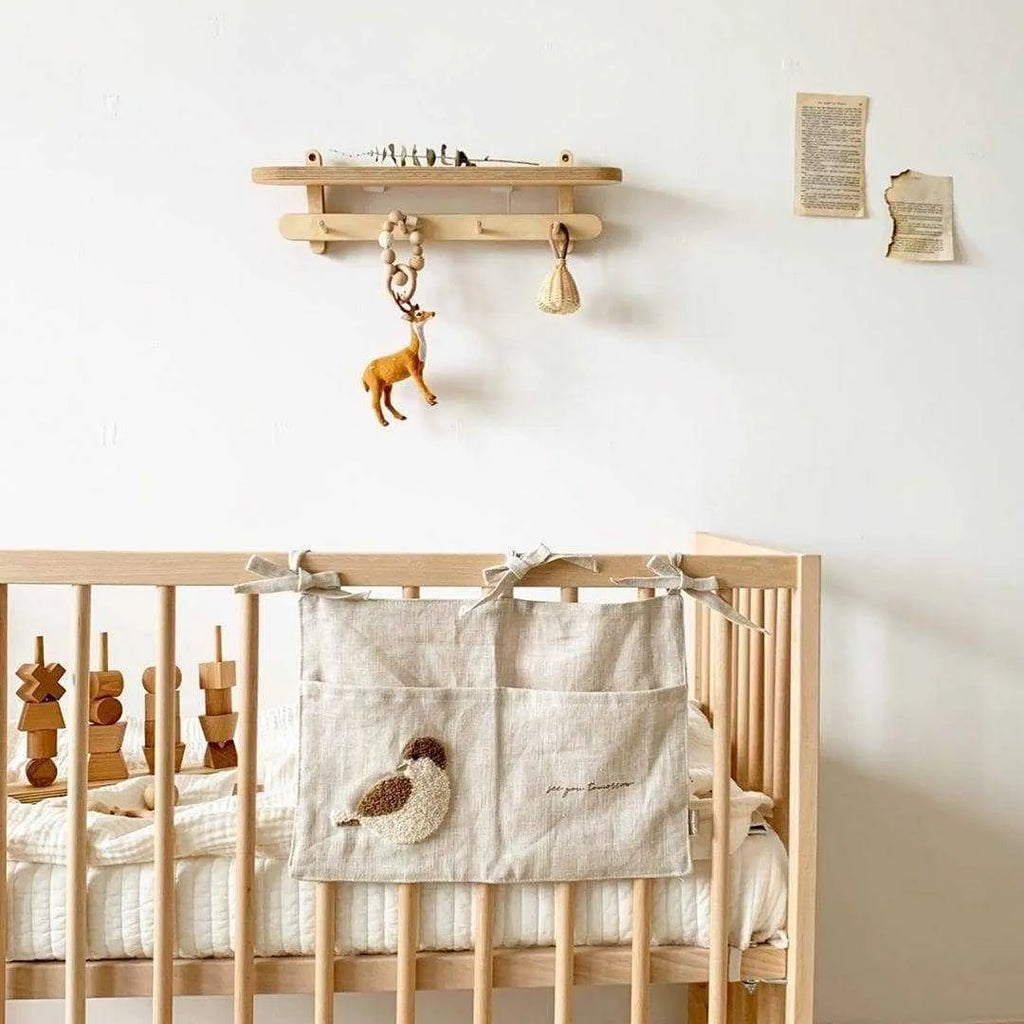 Khaki cotton and linen multi-purpose storage bag hanging beside the bed with single pocket