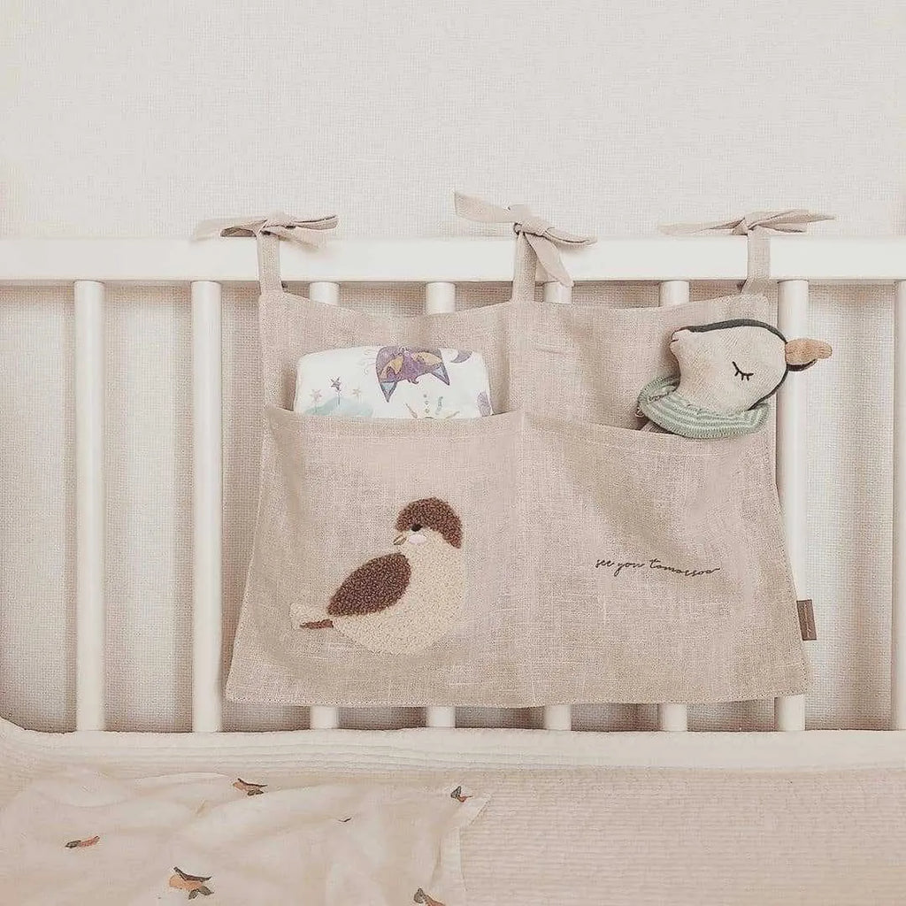 Khaki cotton and linen multi-purpose storage bag hanging beside the bed with single pocket