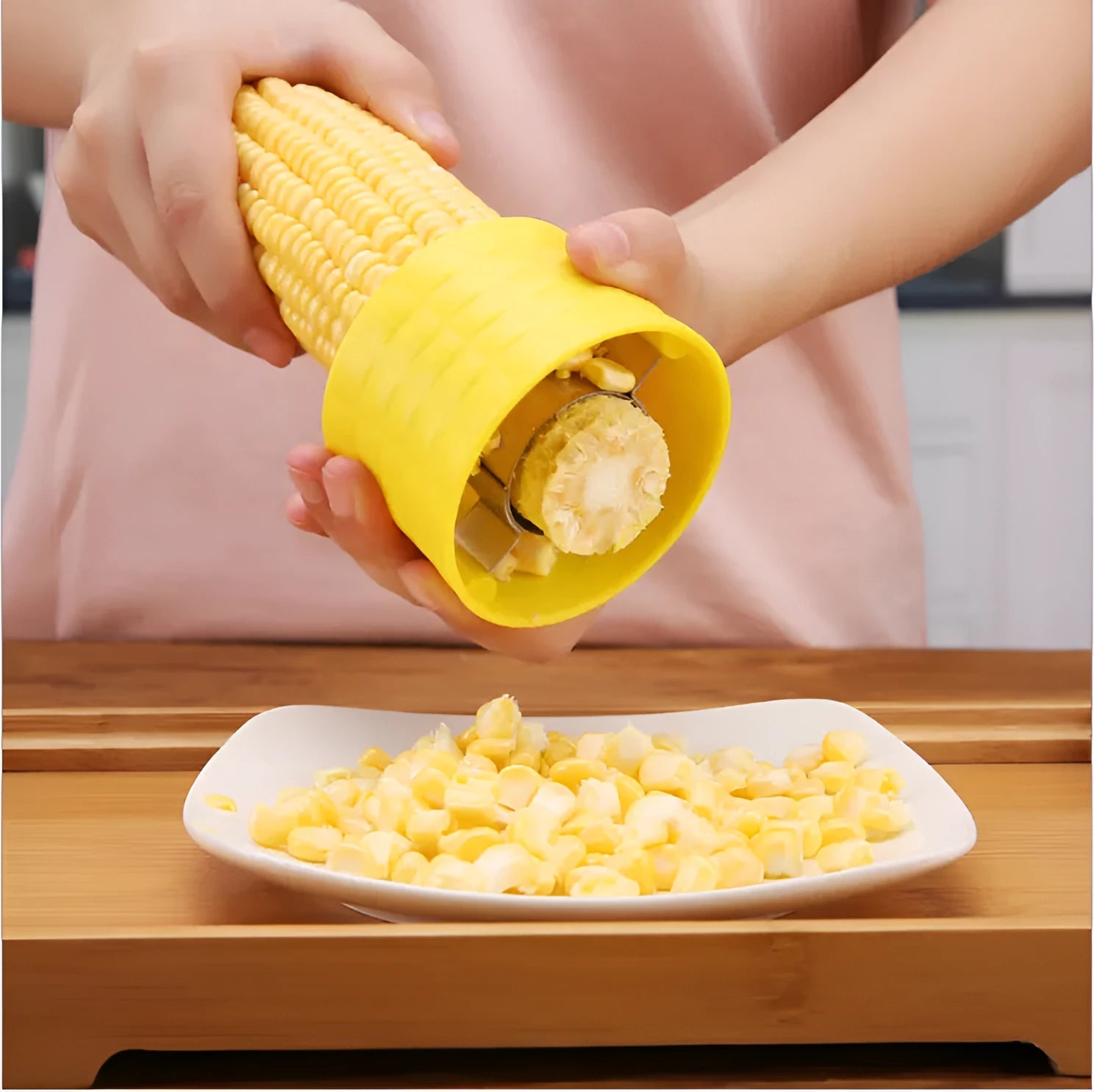 Yellow manual corn thresher with corn-shaped design and stainless steel gear for peeling kernels.