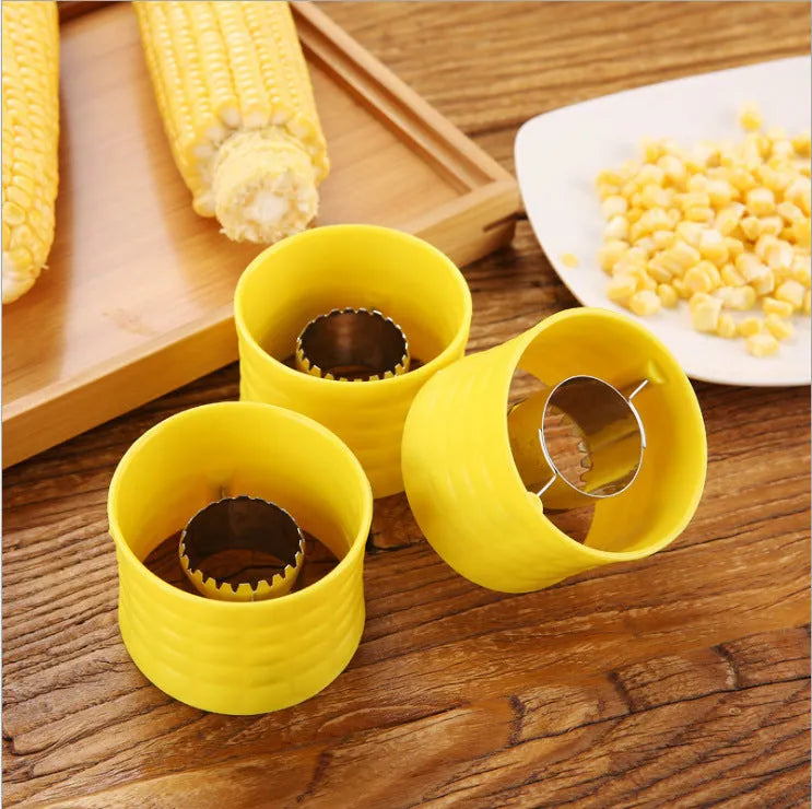 Yellow manual corn thresher with corn-shaped design and stainless steel gear for peeling kernels.