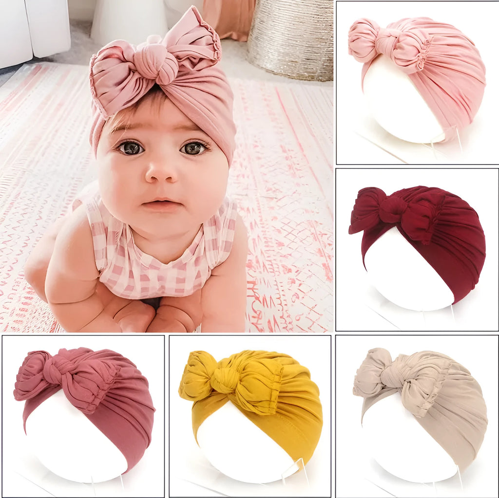 Soft acrylic knitted baby hat in a solid colour, shown on a mannequin as a turban-style cap for infants 0-28 months.