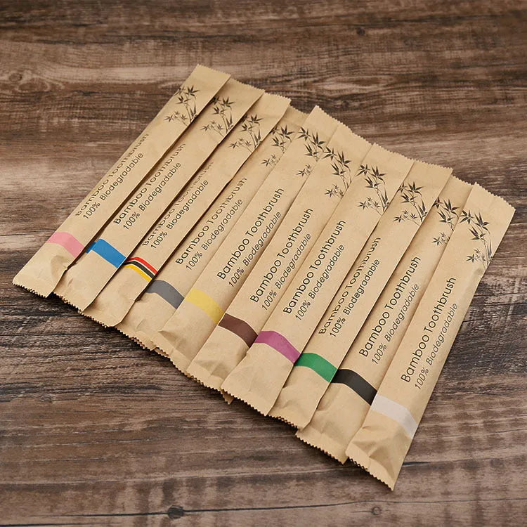 Set of 10 colourful bamboo toothbrushes with black charcoal bristles on a white background.