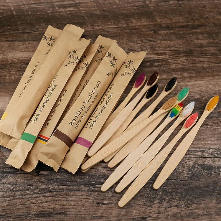 Set of 10 colourful bamboo toothbrushes with black charcoal bristles on a white background.