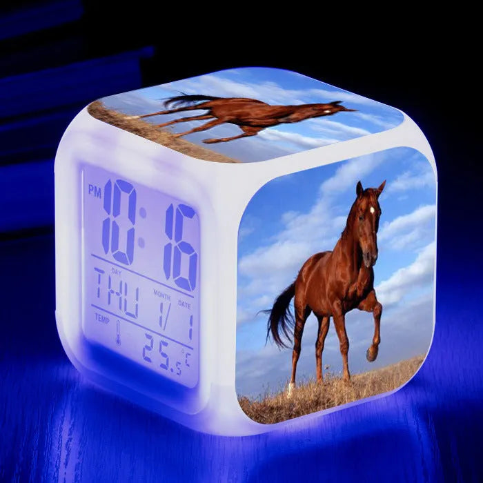 Small colourful square LED alarm clock showing digital time display on plexiglass mirror front