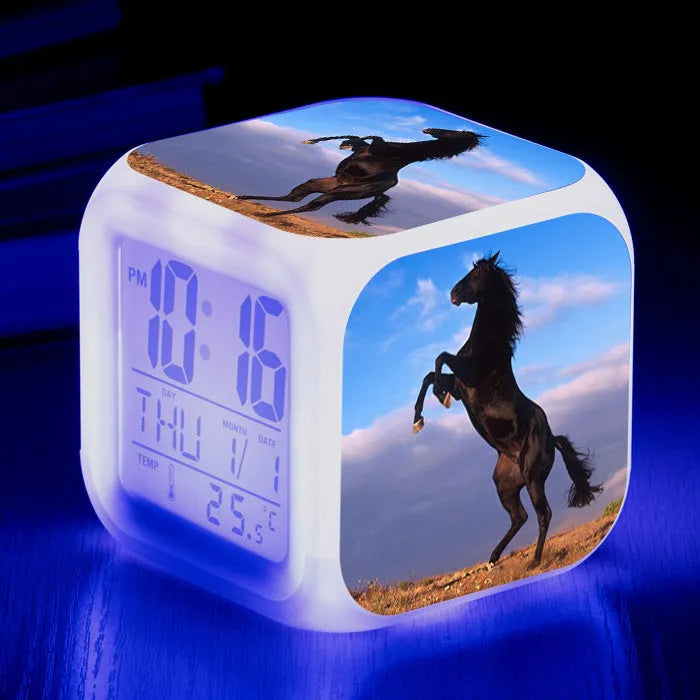 Small colourful square LED alarm clock showing digital time display on plexiglass mirror front