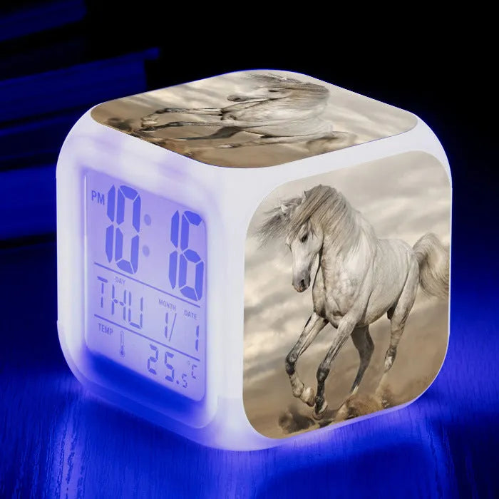 Small colourful square LED alarm clock showing digital time display on plexiglass mirror front