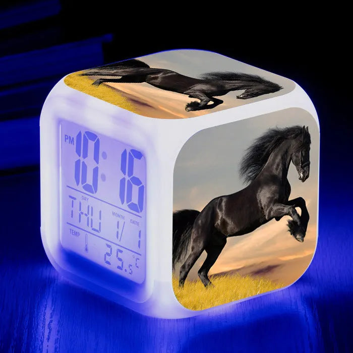 Small colourful square LED alarm clock showing digital time display on plexiglass mirror front