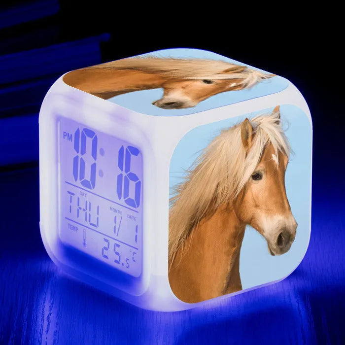 Small colourful square LED alarm clock showing digital time display on plexiglass mirror front