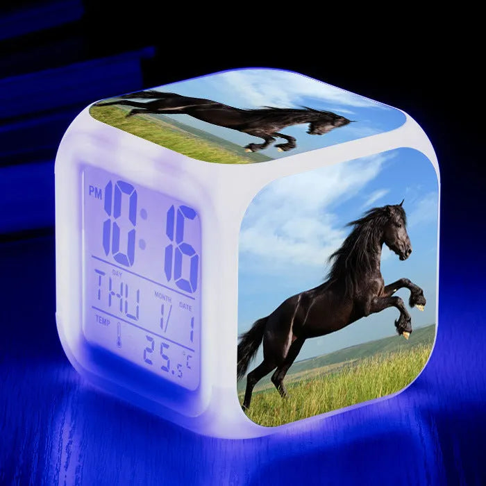 Small colourful square LED alarm clock showing digital time display on plexiglass mirror front