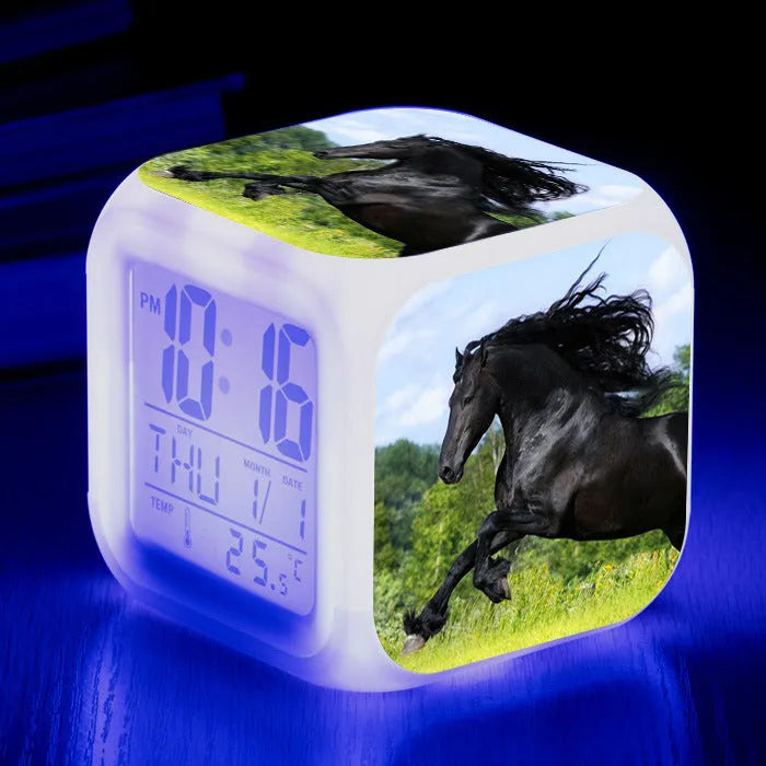 Small colourful square LED alarm clock showing digital time display on plexiglass mirror front