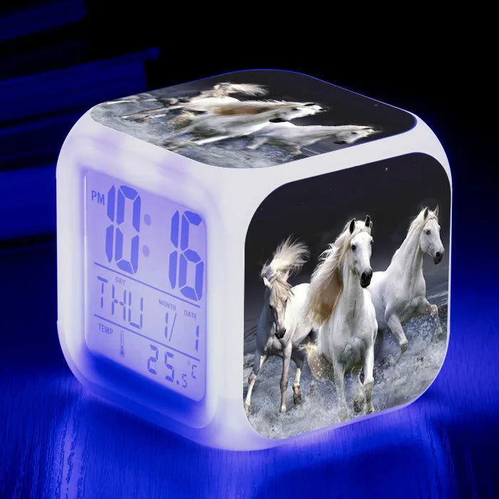 Small colourful square LED alarm clock showing digital time display on plexiglass mirror front