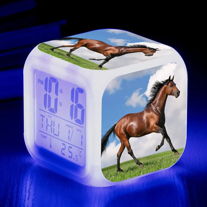 Small colourful square LED alarm clock showing digital time display on plexiglass mirror front