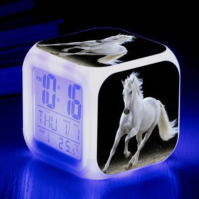 Small colourful square LED alarm clock showing digital time display on plexiglass mirror front