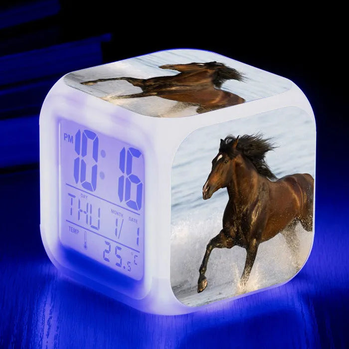 Small colourful square LED alarm clock showing digital time display on plexiglass mirror front
