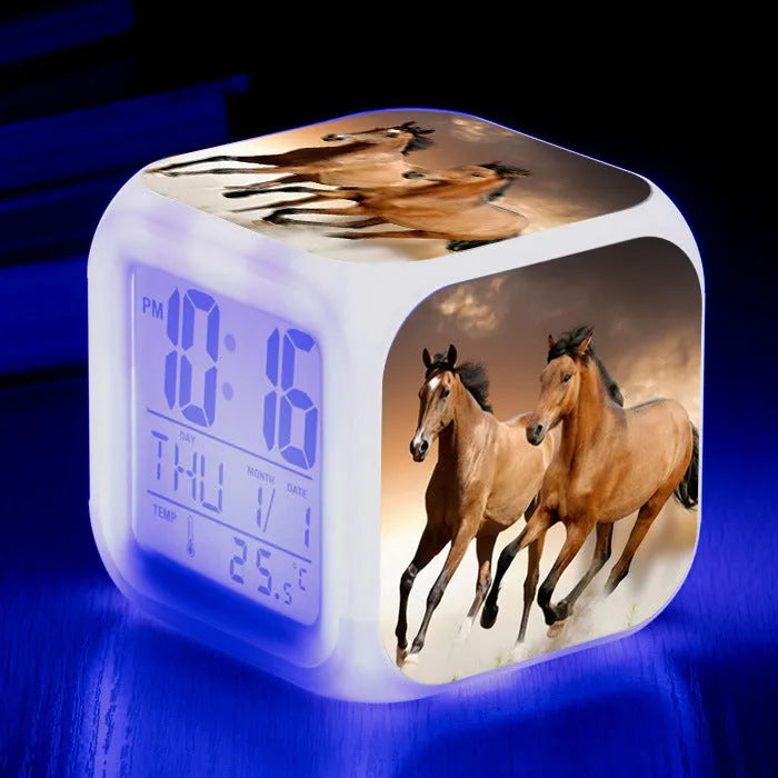 Small colourful square LED alarm clock showing digital time display on plexiglass mirror front